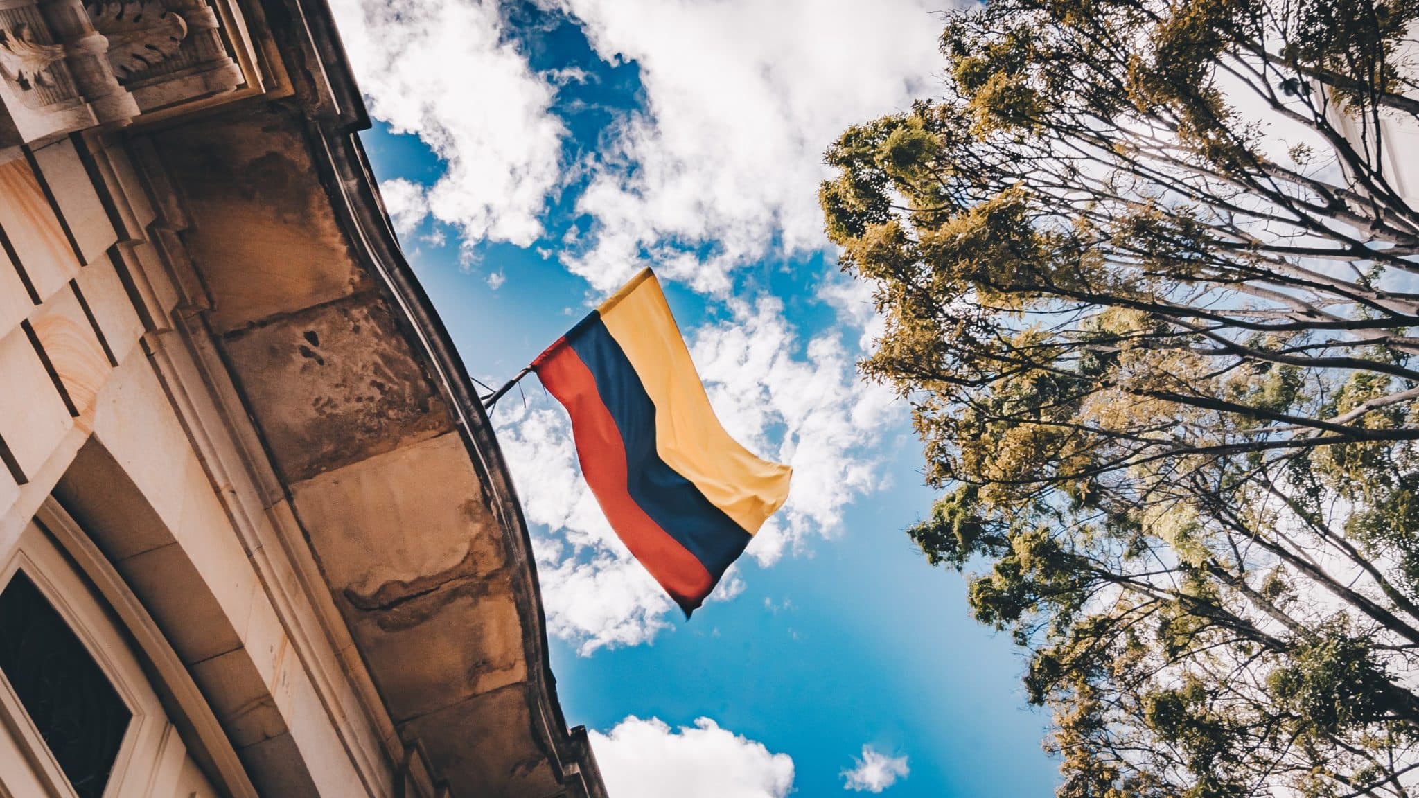 The Colombian flag flying above a colonial building